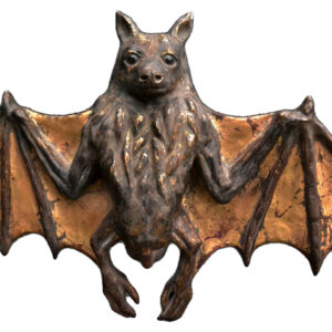 A bat sculpture with wings spread and the head resting on its back.