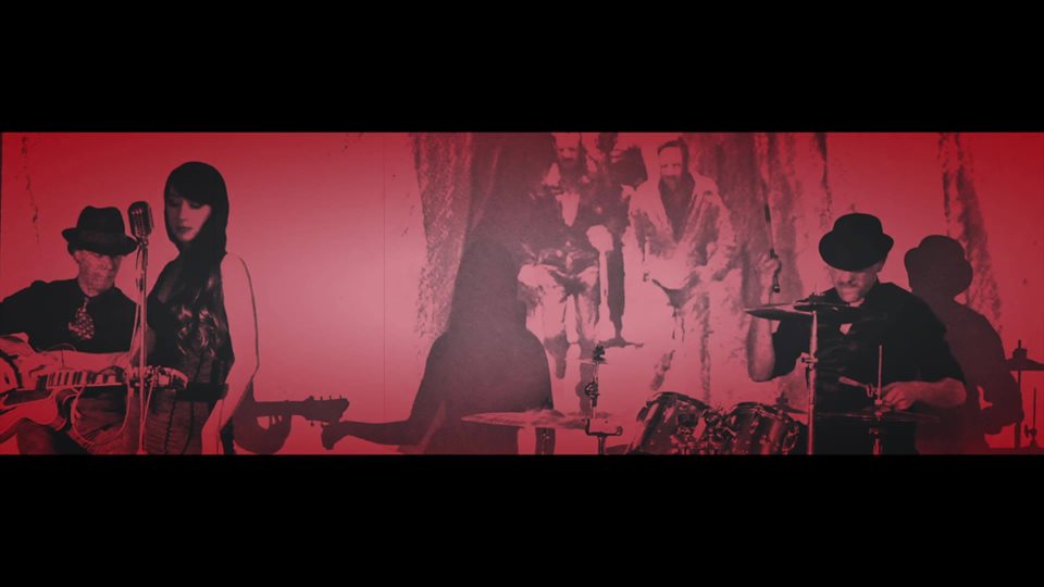 carina-1 Red-tinted band performing on stage.