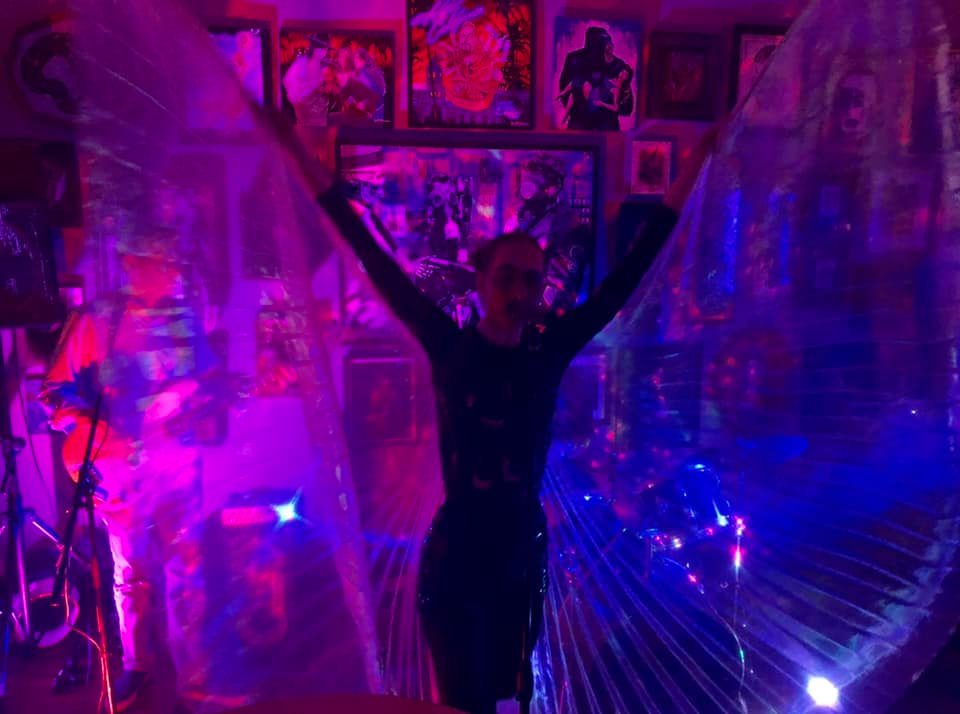 RABBIT_JAW-1 Person with wings in colorful, vibrant room.