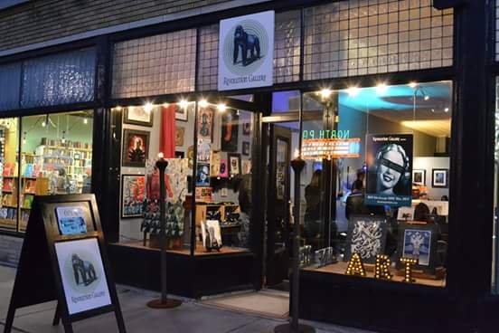 NEW_ABOUT_IMAGE Art gallery with illuminated storefront at night.