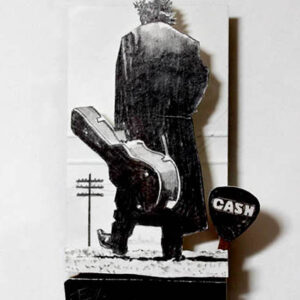 A man holding a guitar standing next to a sign.