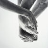 A black and white photo of two hands holding one another