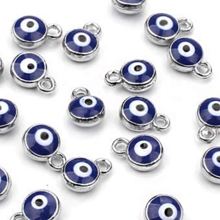 DAY18_EVIL_EYE_CHARM-1 Blue evil eye charms scattered on surface.