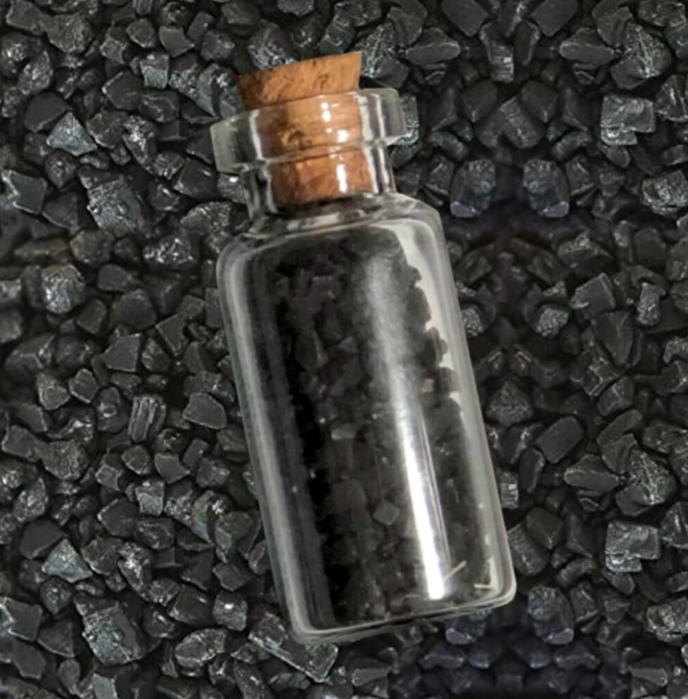Small glass bottle with black granules inside.