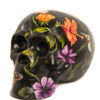 A black skull with flowers painted on it.