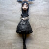A doll with bat wings and black dress