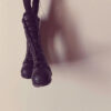 A pair of black boots hanging on the wall.